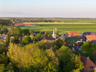Aerial view of Dutch village with church tower and national flag