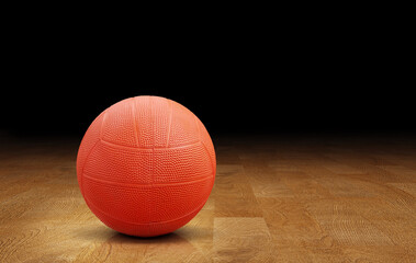 Orange dodgeball on wooden floor, orange rubber ball.