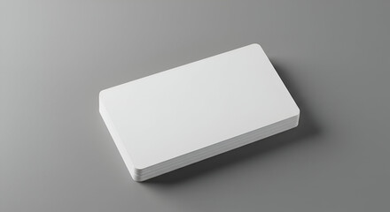 Stack of blank white business cards on a gray surface. A professional presentation of blank cards for branding and design mockups.