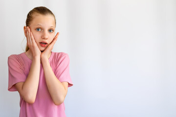 Shocked Girl With Hands on Her Face. Surprised young girl holding her face with both hands,...