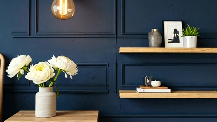 Modern bedroom with navy blue accent wall, stylish decor, and cozy ambiance featuring flowers