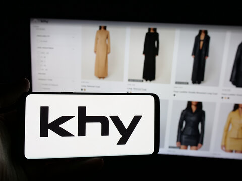 Stuttgart, Germany - 05-25-2025: Person holding smartphone with logo of US fashion company K Brand Inc. (Khy) on screen in front of website. Focus on phone display.
