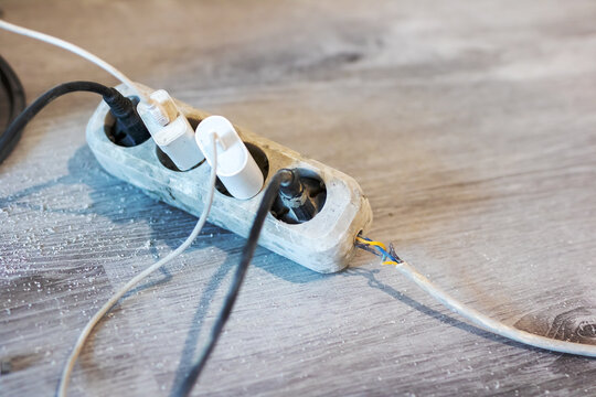 A collection of various electrical wires is connected to a power strip