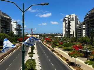 Israeli city, central district, beautiful streets, modern apartment buildings, Israeli flag, Star...