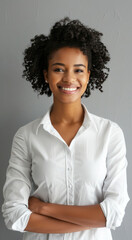 Confident woman smiling in white shirt against grey background