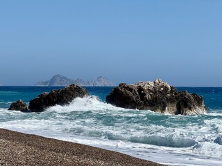 Waves crashing against a rugged rocky shoreline, capturing the raw power and beauty of coastal nature