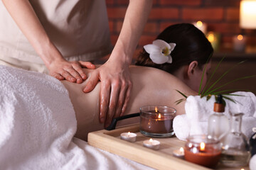 Woman receiving back massage with oil in spa salon