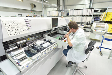 engineering in microelectronics: workers in the production and assembly of electronic high tech components in a modern factory