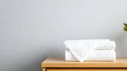Folded White Towels On Wooden Table In Front Of Light Gray Wall