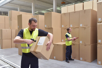 Worker in a warehouse in the logistics sector processing packages on the assembly line  - transport and processing of orders in trade