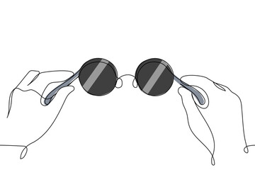 human hands holding sunglasses close up - one line art vector. round frame sunglasses