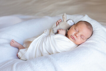 Sweet beautiful baby girl, sleeping in bed with teddy bear, pure colors, infant sleeping 