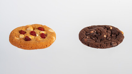 Vanilla cookies topped with nuts and strawberries ฟืก A large chocolate cookie topped with chocolate chips on a white background