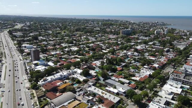 Urban development intersecting scenic coastline, revealing residential neighborhood along rio de la plata waterfront with architectural landscape spanning montevideo suburban areas