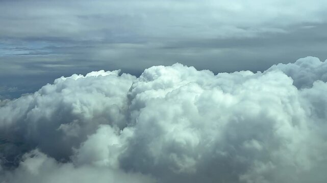 A peaceful cloudscape through the pilot&rsquo;s eyes from cockpit while flying over some cottony white clouds