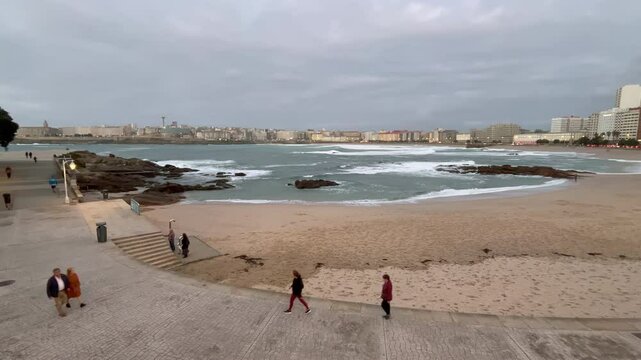 Stunning 4K view of A Coru&ntilde;a from rocky beach, featuring the iconic Tower of Hercules, city skyline, and rolling waves. Perfect for coastal, travel visuals
