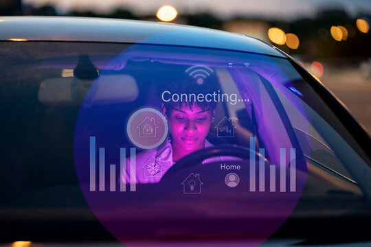 Businesswoman sitting in car with digital display on windshield