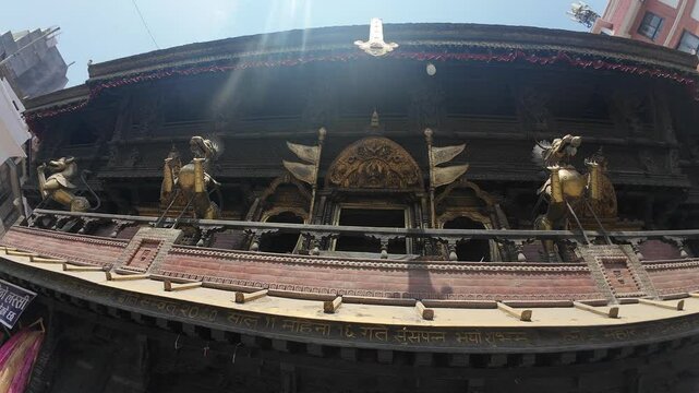 Ornate Exterior of Akash Bhairav Temple in Nepal: Golden Brass Lions, Intricate Wooden Carvings, and Traditional Metalwork