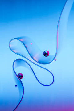 Abstract 3D composition with glass ribbon and spheres on a neon background