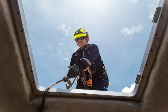Engineer climbing out of a wind turbine nacelle during maintenance outdoors
