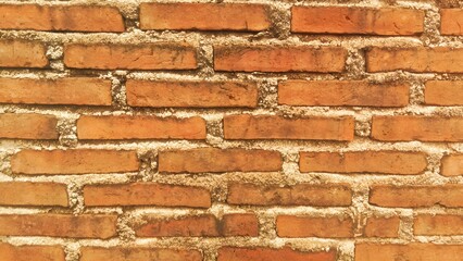 Fototapeta premium Close-up of a traditional red brick wall with rough cement joints. 