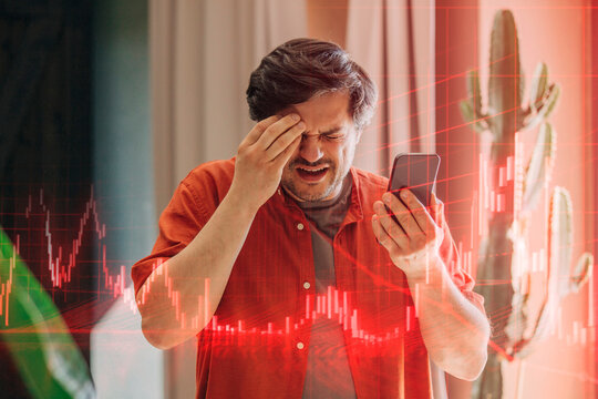 Man in red shirt looking at smartphone with horror as stock market falls
