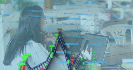 Image of graphs and financial data over woman having image call on laptop