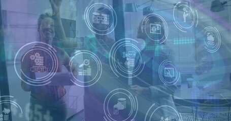 Image of financial data and icons over diverse coworkers in office