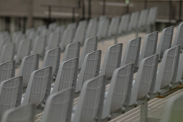 Fototapeta premium A row of utterly empty gray stadium seats situated within a sports venue, beautifully showcasing the overall seating layout and innovative design elements incorporated into the arena