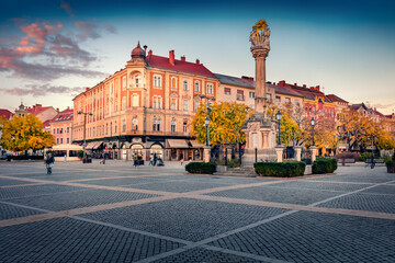 Impressive evening view of Main square with Csaszarko monument in Szombathely. Picturesque autumn sunset in Hungary, Europe. Nice cityscape of Szombathely town. Traveling concept background.