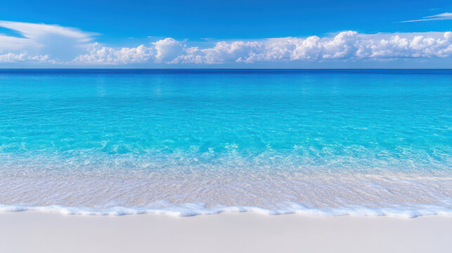Crystal clear turquoise sea meets sandy beach under bright blue sky, creating serene atmosphere