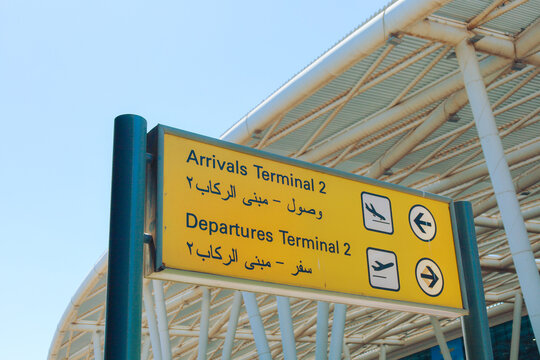 Bilingual Direction Sign at Egyptian Airport on a Sunny Day