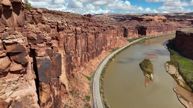 High angle View of Road next to Red Steep Cliffs and River, Potash Road in Moab Utah, train tracks, Colorado River, Lower Colorado Scenic Byway, Close up