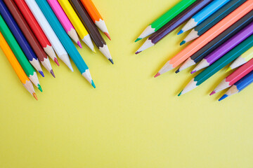 Obraz premium Colored pencils on a yellow background. Bright juicy background for inscriptions. Summer background. School. September 1. Office. Study.