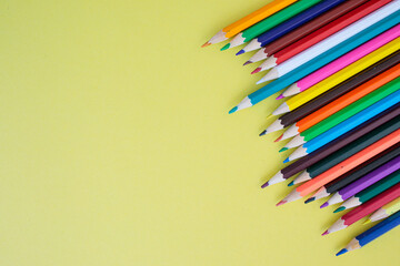 Colored pencils on a yellow background. Bright juicy background for inscriptions. Summer background. School. September 1. Office. Study.