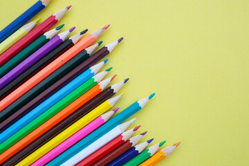 Colored pencils on a yellow background. Bright juicy background for inscriptions. Summer background. School. September 1. Office. Study.