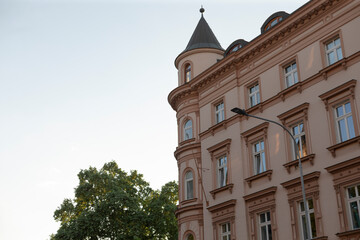 The buildings impressive exterior features a towering structure, large glass windows, and lush...