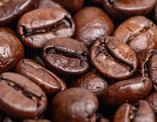 Closeup reveals intricate details of coffee beans, showcasing their dark brown skins and rich textures, evoking warmth