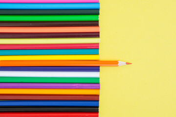 Colored pencils on a yellow background. Bright juicy background for inscriptions. Summer...