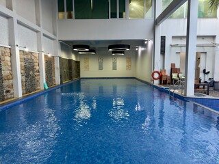 An indoor swimming pool with clear and still water reflecting soft lighting