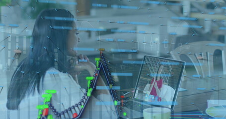Image of graphs and data over woman having image call on laptop