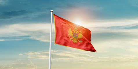 Montenegro national flag waving in beautiful sky with mast. A proud moment flag waving with sunlight.