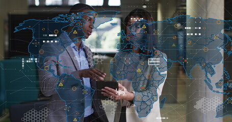 Image of world map over diverse business people in office