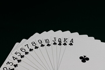 Playing Cards of Club Suit Arranged in a Perfect Arc on Dark Background