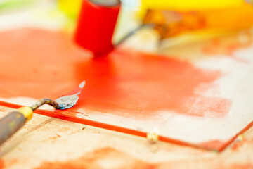 desktop graphics with a roller with red paint and a palette knife