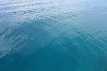Tranquil Blue Sea with Gentle Waves. A serene view of light waves forming subtle textures on the blue surface of the tropical sea, showcasing the ocean’s peaceful rhythm.