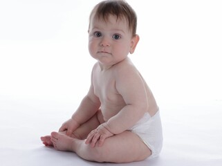 Cute little baby in diaper sitting on white background