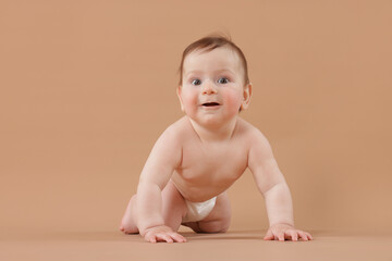Cute little baby crawling on beige background