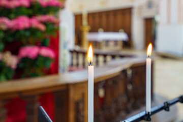 Candles burning at a serene altar within a peaceful church setting during a quiet moment of...