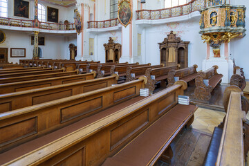 Interior of a historic church featuring wooden pews and ornate architecture during daylight hours...